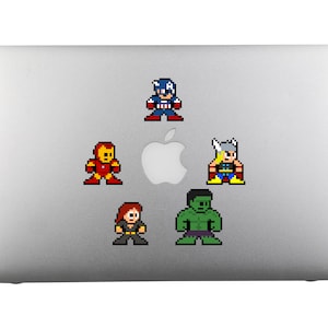 May include: A silver laptop with five pixelated superhero stickers: Captain America, Iron Man, Thor, Hulk, and Black Widow.