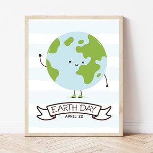 May include: A framed print featuring a cartoon Earth with a smiling face and waving arm. The Earth is light blue with green continents, set against a striped background. The banner below reads "Earth Day April 22".
