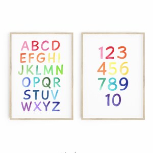 May include: Two framed prints with a white background. The left print features the alphabet in rainbow colors. The right print features the numbers 1 through 10 in rainbow colors. The prints are labeled "Charlie & Pig".