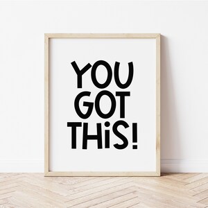 May include: A framed print with a white background and black text that reads "YOU GOT THIS!" in a playful, bold font.