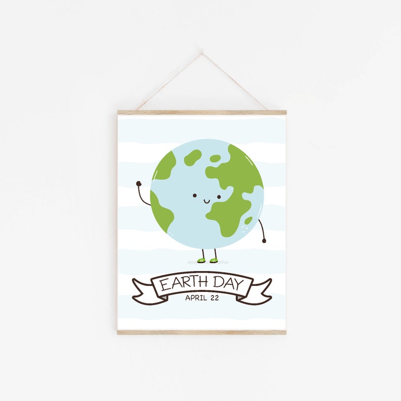 May include: A framed Earth Day print featuring a smiling Earth with green continents and a light blue ocean. The print includes the text "Earth Day April 22" on a banner, set against a backdrop of blue and white stripes.
