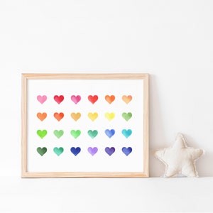 May include: A framed print with a white background and 24 watercolour hearts in a rainbow colour pattern. The hearts are arranged in four rows of six hearts each.