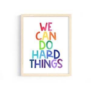 May include: A framed print with the text "WE CAN DO HARD THINGS" in a rainbow color scheme.