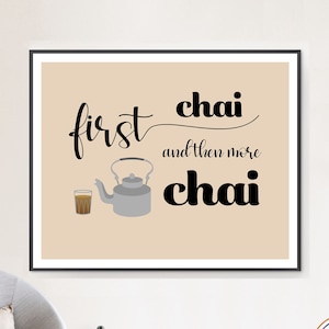May include: A framed print with the words "first chai and then more chai" in black script. The image includes a gray teapot, a glass of chai, and a beige background. The print is displayed on a wall above a gray chair.
