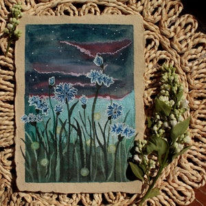 Könnte beinhalten: Ein Gemälde auf Leinwand, das ein Feld mit blauen Kornblumen unter einem sternenklaren Nachthimmel darstellt. Die Blumen sind in Blautönen und Grüntönen gemalt, vor einem dunkelblauen Hintergrund. Das Gemälde ist in einem einfachen braunen Rahmen gerahmt.