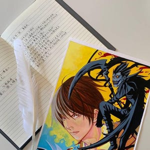 Può includere: Un'illustrazione dipinta a mano di un personaggio dell'anime Death Note. Il personaggio tiene un quaderno nero con le parole "Death Note" scritte su di esso. Il personaggio è circondato da uno sfondo giallo con accenti rossi e blu.