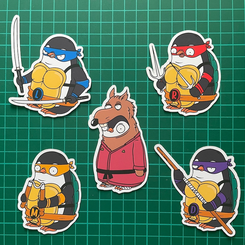 Puede incluir: Cinco pegatinas de dibujos animados con ping&uuml;inos vestidos como las Tortugas Ninja. Las pegatinas est&aacute;n sobre un fondo verde. Los ping&uuml;inos llevan bandanas rojas, azules, moradas y naranjas. Las pegatinas muestran las letras 'L', 'R', 'M' y 'D' en el pecho de los ping&uuml;inos.