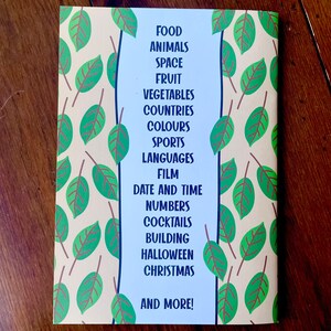 May include: A book cover with a green and brown leafy pattern. The text on the cover reads "FOOD, ANIMALS, SPACE, FRUIT, VEGETABLES, COUNTRIES, COLOURS, SPORTS, LANGUAGES, FILM, DATE AND TIME, NUMBERS, COCKTAILS, BUILDING, HALLOWEEN, CHRISTMAS, AND MORE!"