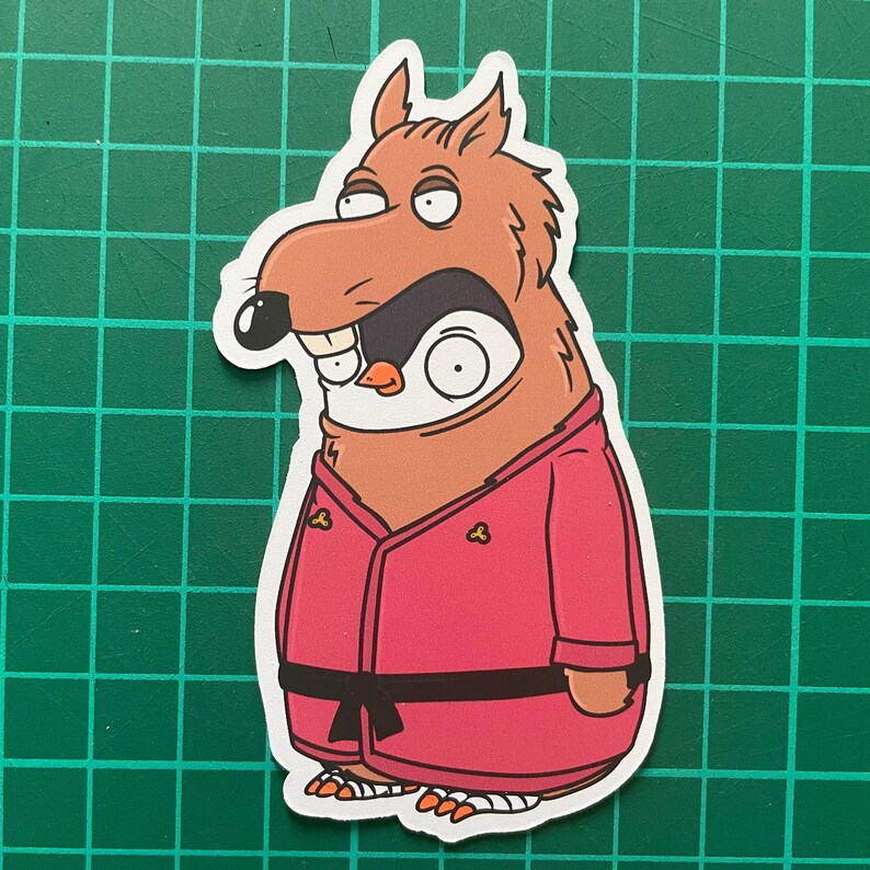 Puede incluir: Una ilustraci&oacute;n de dibujos animados de un animal marr&oacute;n y rojo que lleva un kimono de karate rosa con un cintur&oacute;n negro. El animal tiene una cabeza de ping&uuml;ino con una m&aacute;scara negra para los ojos y un pico blanco.