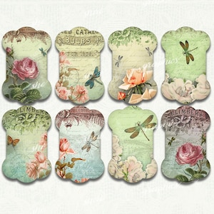 Op de afbeelding: Acht vintage papieren labels met bloemen- en libellenontwerpen. Elk label toont rozen, vlinders en scripttekst in roze, groen en bruin. De labels hebben een decoratieve vorm, die doet denken aan ouderwetse labels.