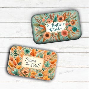May include: Two rectangular decorative trays with floral designs. One features the text "trust in the Lord" on a light blue background with orange and teal flowers. The other has "Praise the Lord!" on a beige background with autumn leaves and flowers.