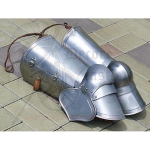 May include: A pair of silver knee armor with leather straps. The armor is made of metal and has a rounded shape. The straps are brown leather and are attached to the armor with metal buckles.