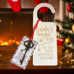 May include: A white wooden door hanger with the text "Santa's magic key for our home without a chimney." A decorative key is attached with a red ribbon. A small card with text is also attached.