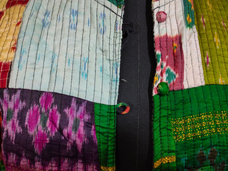 Puede incluir: Una chaqueta de tela de patchwork con una variedad de colores y patrones, incluyendo verde, rosa, azul y amarillo. La chaqueta tiene una cremallera negra y un cierre de bot&oacute;n.