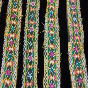 May include: Five strips of colourful embroidered trim with a black background. The trim features a repeating pattern of geometric shapes, small mirrors, and colourful thread.