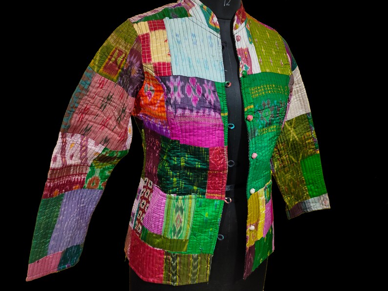 Puede incluir: Una chaqueta de patchwork con cuello mandar&iacute;n y cierre de botones. La chaqueta est&aacute; hecha de una variedad de telas coloridas, incluyendo verde, rosa, morado y azul.