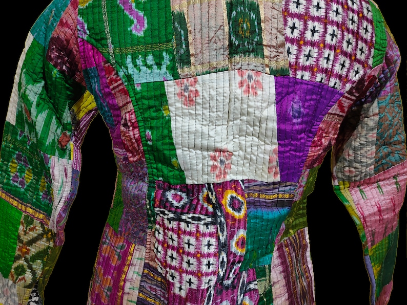 Puede incluir: Una chaqueta de patchwork hecha de diferentes telas en tonos de verde, morado, rosa y blanco. La chaqueta tiene un dise&ntilde;o acolchado y est&aacute; hecha de seda.