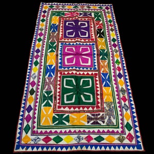 May include: A colorful patchwork quilt with a white background and intricate geometric patterns in shades of green, purple, pink, yellow, and blue. The quilt is bordered with a multi-colored trim.