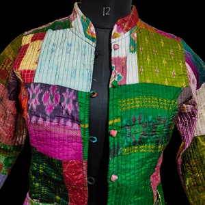 Puede incluir: Una chaqueta de patchwork con cuello mandar&iacute;n y cierre de botones. La chaqueta est&aacute; hecha de diferentes telas en varios colores, incluyendo verde, rosa, morado y azul.