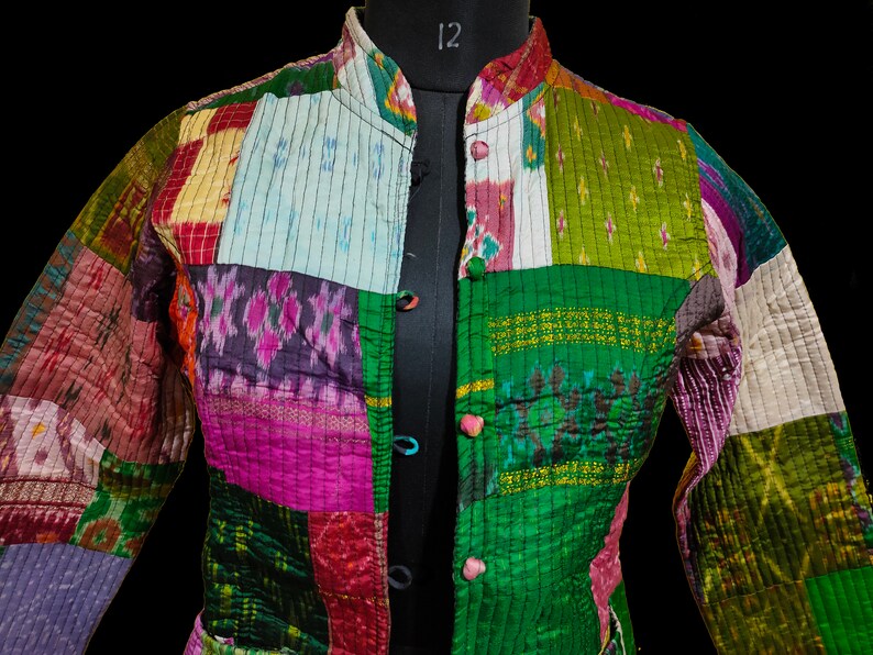 Puede incluir: Una chaqueta de patchwork con cuello mandar&iacute;n y cierre de botones. La chaqueta est&aacute; hecha de diferentes telas en varios colores, incluyendo verde, rosa, morado y azul.