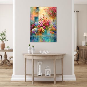 a vibrant and colorful painting of flowers hanging on a wall above a wooden console table with decorative items on it.