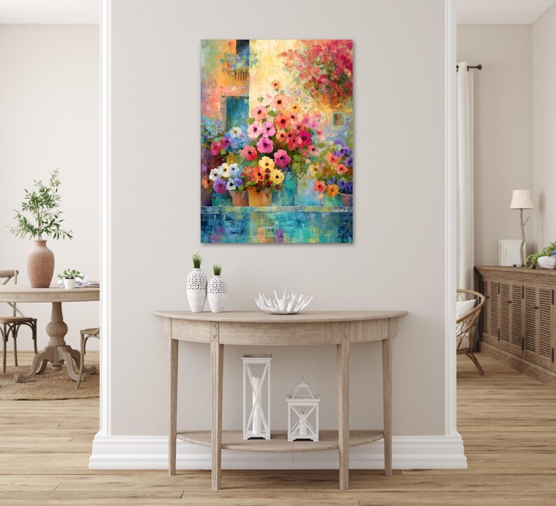 a vibrant and colorful painting of flowers hanging on a wall above a wooden console table with decorative items on it.