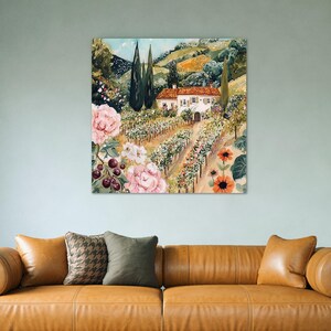 a large painting of a countryside scene with a house, flowers, and trees hanging on a wall above a brown leather couch.