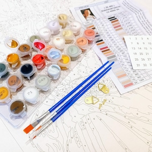 a table topped with lots of paint and brushes