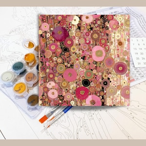 May include: A paint-by-numbers kit with an abstract floral design in pink, gold, and brown tones. The kit includes paint pots, brushes, and a numbered canvas. The artwork has a modern, artistic style, suitable for home decor.