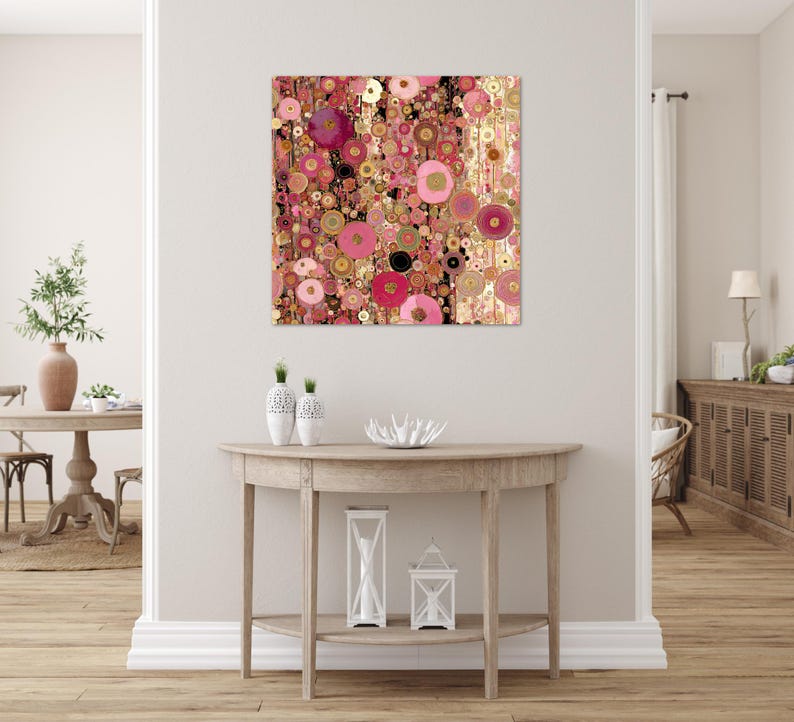 May include: Abstract art print with a pattern of overlapping circles in pink, gold, and black. The artwork hangs on a white wall above a wooden console table, creating a modern interior design. The artwork is a square.