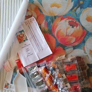 various craft supplies, including a colorful floral pattern, a roll of paper, and several packages of craft materials.