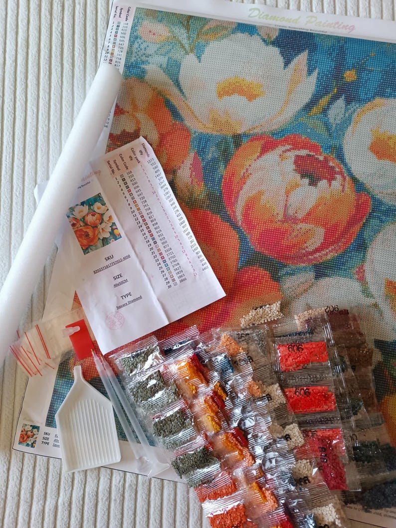 various craft supplies, including a colorful floral pattern, a roll of paper, and several packages of craft materials.