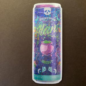 May include: A holographic sticker of a can of energy drink with a witch's brew theme. The can is purple and green with a skull, cauldron, and stars. The text on the can reads "Witch's Brew" and "Energy!"