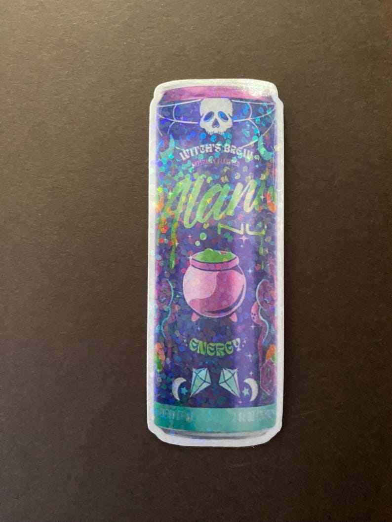 May include: A holographic sticker of a can of energy drink with a witch's brew theme. The can is purple and green with a skull, cauldron, and stars. The text on the can reads "Witch's Brew" and "Energy!"