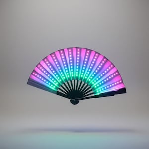 May include: A black folding fan with LED lights. The fan is open, displaying a gradient of colors from pink to green, with white lights in rows. The fan is a decorative item.