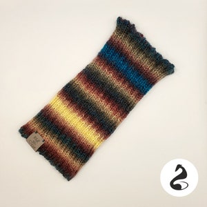 Könnte beinhalten: Mehrfarbiger gestrickter Armwärmer mit Streifen und einem braunen Etikett mit der Aufschrift "Made with Love".