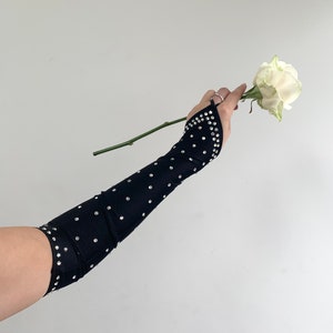 K&ouml;nnte beinhalten: Schwarze Ellbogenlange Handschuhe mit Strasssteinmuster.