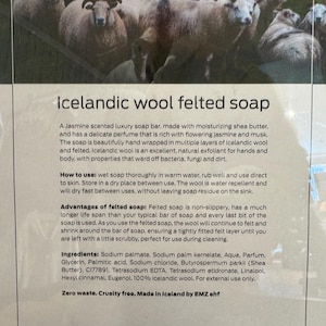 May include: A bar of Icelandic wool felted soap with a white label that reads "Icelandic wool felted soap". The label describes the soap as a jasmine scented luxury soap bar made with moisturising shea butter and a delicate perfume that is rich with flowering jasmine and musk. The label also describes the soap as being beautifully hand wrapped in multiple layers of Icelandic wool and felted. The label also describes the soap as being an excellent, natural exfoliant for hands and body, with properties that ward off bacteria, fungi and dirt. The label also describes how to use the soap, the advantages of felted soap, and the ingredients. The label also states that the soap is zero waste, cruelty free, and made in Iceland by EMZ ehf.