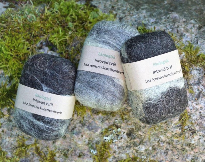 May include: Three black and grey felted soap bars with white labels that read "Ekologisk Intovad tv&aring;l Lisa Jonsson konsthantverk".