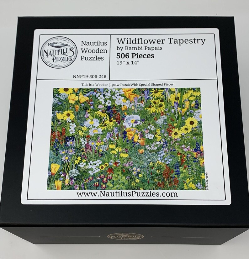 May include: A black box featuring a colorful Wildflower Tapestry jigsaw puzzle by Bambi Papais. The puzzle contains 506 pieces and measures 19 inches by 14 inches. The box also displays the Nautilus Wooden Puzzles logo and website.