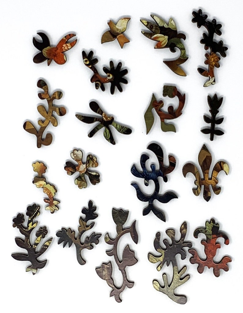 May include: A set of 17 wooden jigsaw puzzle pieces featuring intricate floral and bird designs. The pieces are painted in a variety of colors, including brown, blue, green, and red. The pieces are all different shapes and sizes, and they are all cut out in a way that makes them fit together perfectly.