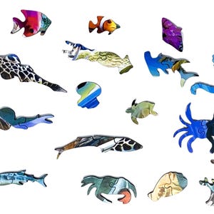 May include: Wooden jigsaw puzzle pieces in the shape of various sea creatures, including fish, a seahorse, and a crab. The pieces are painted with vibrant colors and detailed patterns, creating a visually appealing puzzle.