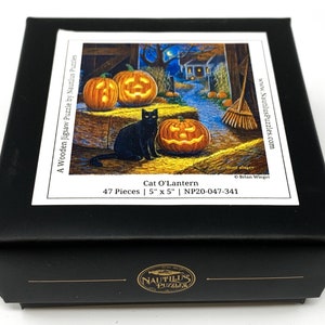 May include: A black cat sits near a jack-o-lantern in a barn setting. The 47-piece wooden jigsaw puzzle is titled "Cat O'Lantern" and measures 5 inches by 5 inches.