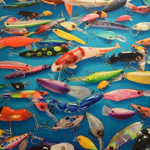 May include: A collection of colorful fishing lures, including a variety of shapes, sizes, and colors. The lures are arranged on a blue background.