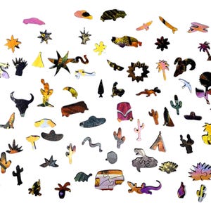 May include: A collection of wooden puzzle pieces in various shapes and colors, including cacti, stars, animals, and other desert-themed designs. The pieces are scattered against a white background, showcasing the intricate details and vibrant hues.