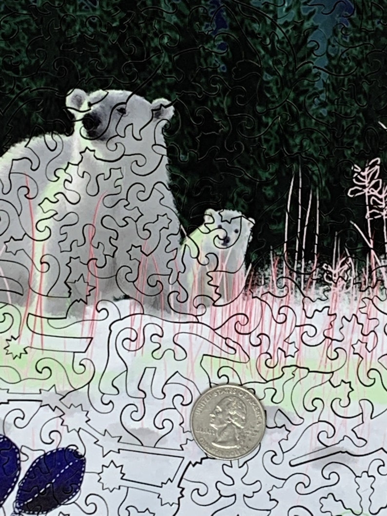 May include: A black and white jigsaw puzzle with a detailed design of two polar bears in a forest setting. The puzzle is partially assembled, with a quarter visible in the lower right corner.