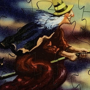 Może przedstawiać: Puzzle w stylu vintage przedstawiające wiedźmę na miotle na tle zachmurzonego nieba. Wiedźma ma na sobie ż&oacute;łty kapelusz i czerwoną suknię, a obok leci czarny kot. Widoczne są elementy układanki.