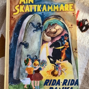 May include: A vintage children's book titled "Min Skattkammare" with a colourful illustration of a giant holding a door open to reveal a treasure room. The book cover also features a small child with a green hat and a girl with a red dress.