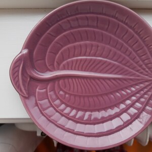 Könnte beinhalten: Eine violette Keramik-Schale in Blattform mit einem erhabenen Design. Die Schale hat eine glänzende Oberfläche und ist perfekt zum Servieren von Snacks oder Vorspeisen.