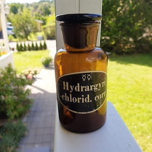 Antiguo frasco de boticario de cristal ámbar con tapón cortado. Añada europea de los años 50.